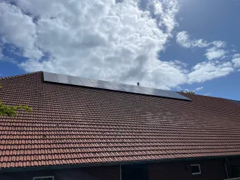 Een groot dak van een boerderij schoonmaken