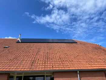 Een groot dak van een boerderij schoonmaken